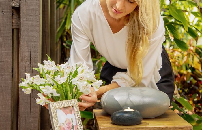 Eternity Pebble Adult Funeral Urn on display in the home with a woman in the background