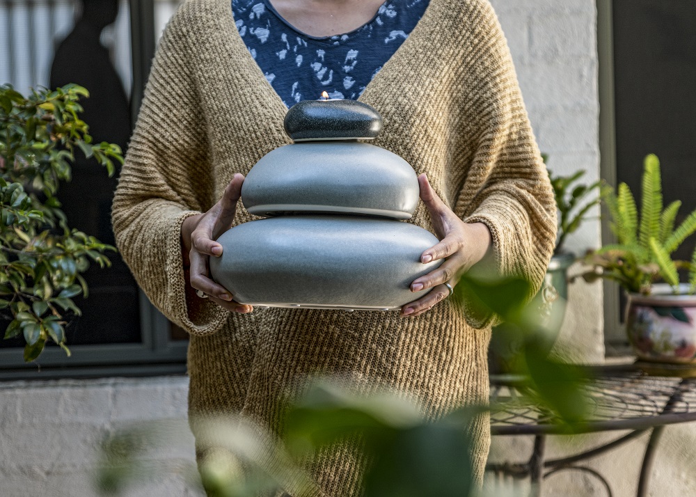 XL Adult Eternity Pebble Funeral Urn Stack held by grieving woman
